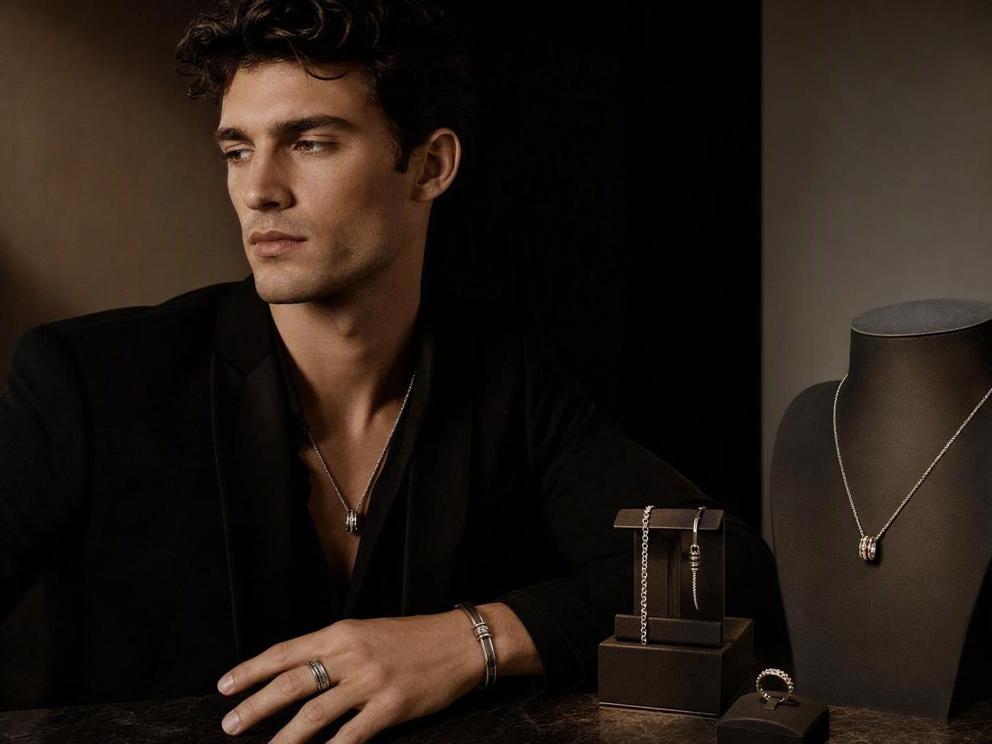 Modelo masculino con un collar de plata minimalista, anillo y pulsera.